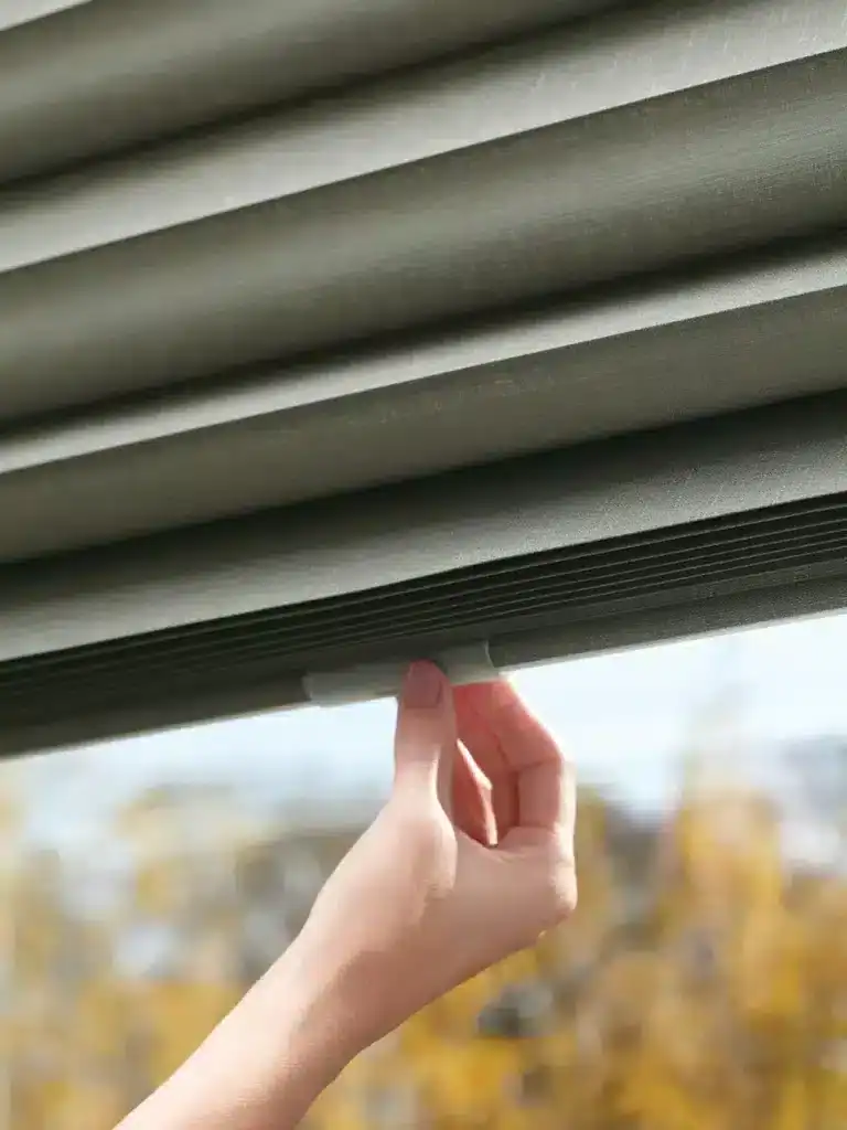 Custom window blinds in a neutral gray fabric, showcasing superior craftsmanship and modern style for home or office window treatments.