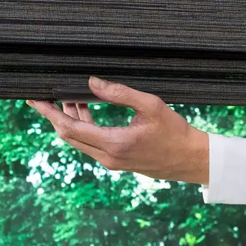 Soft gray window blinds being installed or adjusted, showcasing high-quality window treatments for home or office.