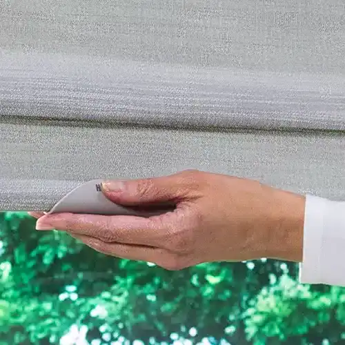 Seamless window blinds installation with a hand using a remote control, showcasing modern and clean window treatment solutions.