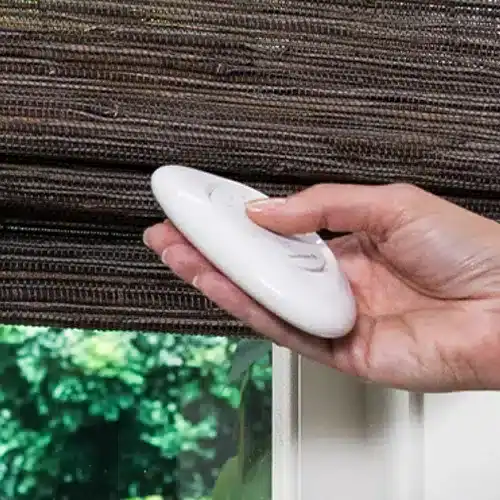 Scaling a window with a remote control for smart blinds and drapery solutions, close-up of hand adjusting window treatment for privacy and light control, residential window covering automation.