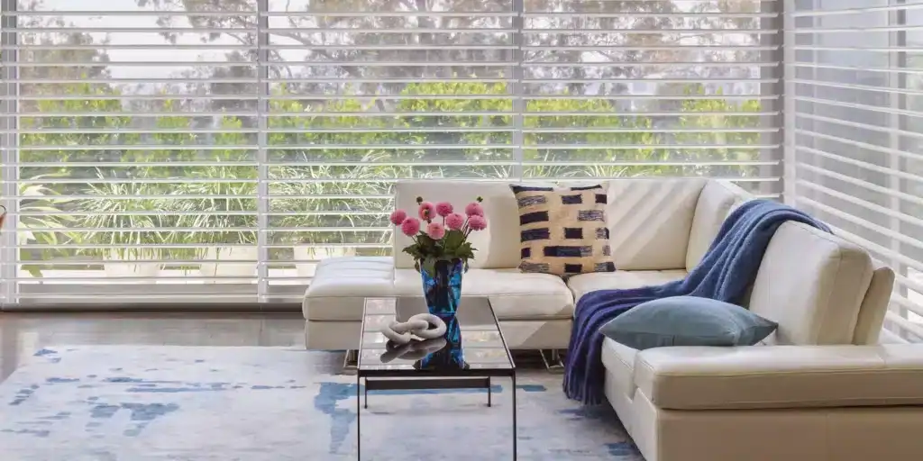 Luxurious white horizontal blinds adorning large windows in modern living room, enhancing privacy and light control, perfect for home decor and window treatments.