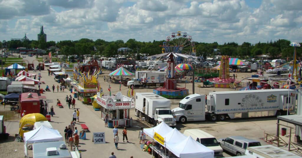 Colorful carnival fairground with rides, food stalls, and visitors at the outdoor event, capturing the lively atmosphere and entertainment options.