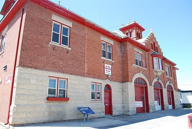Modern brick building with windows and garage doors, showcasing commercial property space in a city setting for lease or sale.